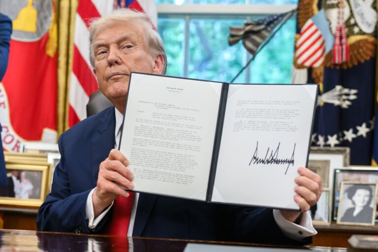 Donald Trump muestra una orden ejecutiva firmada en la Oficina Oval de la Casa Blanca
