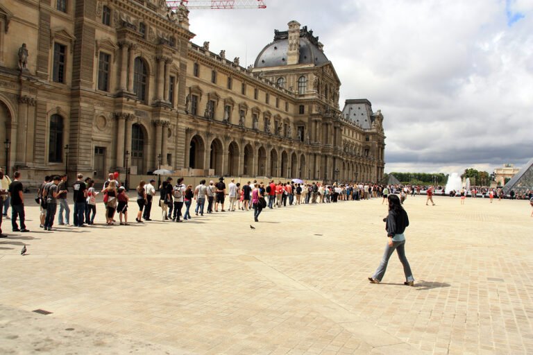 Fila de turistas esperando para entrar al Museo del Louvre en París